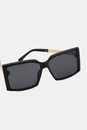 Black geometric sunglasses with gradient lenses and gold temple accents.