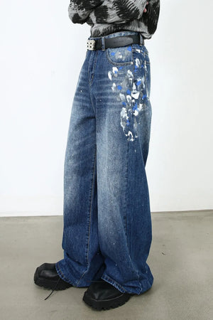 Painterly denim palazzo trousers in medium wash with blue and white paint splatters.