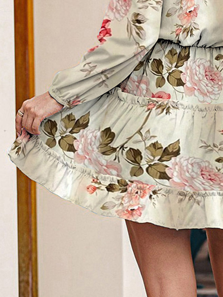 Ivory floral print tiered mini dress with ruffled hem and long sleeves.