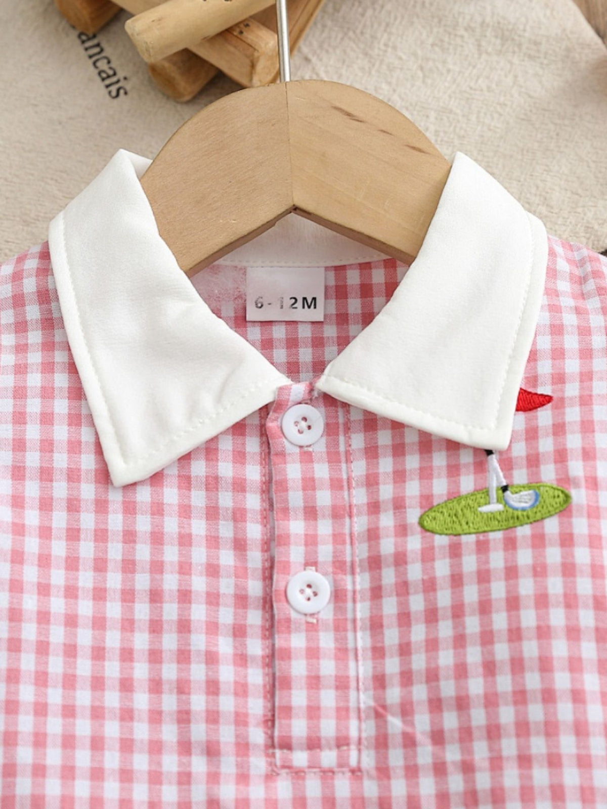Baby pink gingham polo dress with white collar and golf embroidery detail.