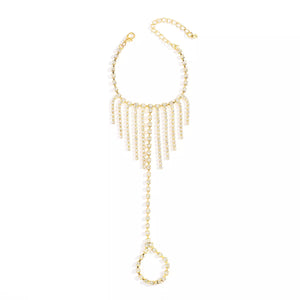 Gold rhinestone fringe hand chain bracelet with a ring and adjustable clasp.