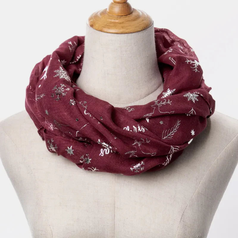 Burgundy infinity scarf with metallic Christmas print featuring snowflakes and reindeer.