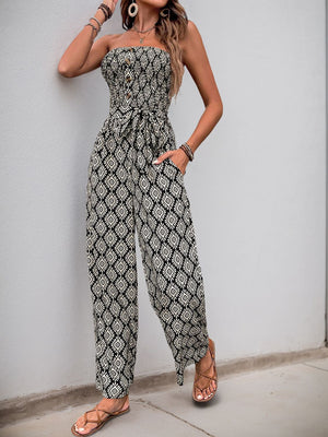 Black geometric print bandeau jumpsuit with smocked bodice, button detail, and tie belt.