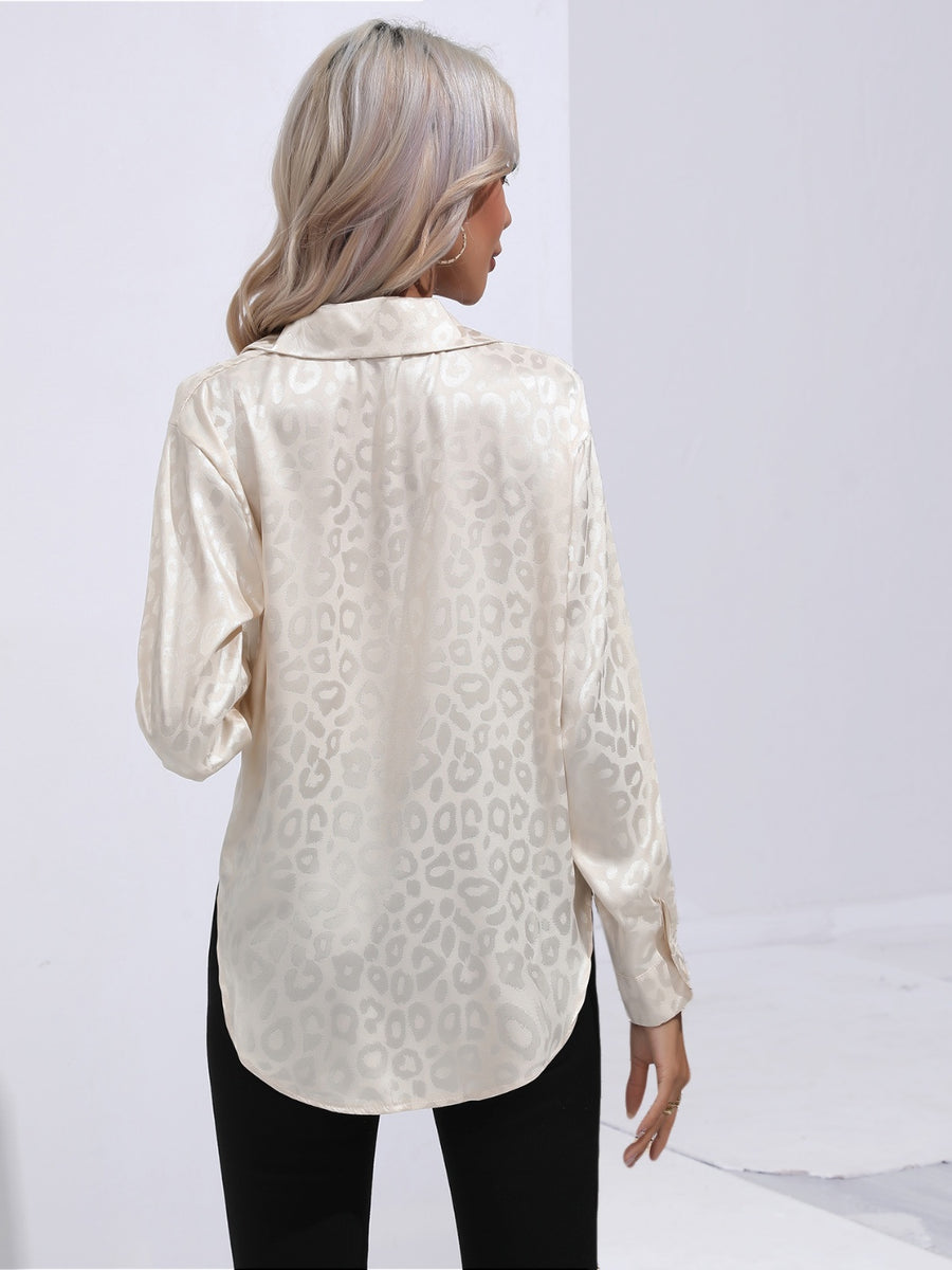 Cream satin leopard print blouse with button cuffs and a collared neckline.
