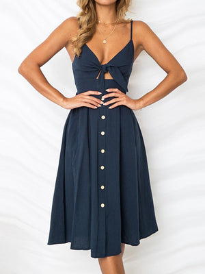 Dark blue midi sundress with bow front, button detail, and cami straps.