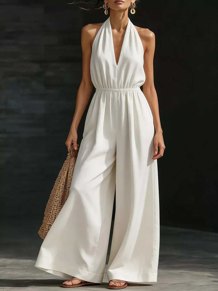 White wide-leg halter jumpsuit with a deep V-neck and elastic waist.
