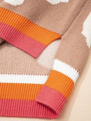 Baggy sweater in tan with a floral pattern and striped cuffs in pink, orange, and white.