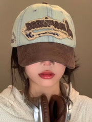 Distressed denim baseball cap in light cowboy blue with brown brim and embroidered logo.