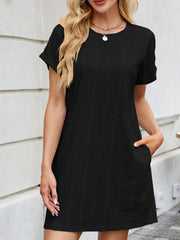 Black eyelet mini dress with crew neck, short sleeves, and pockets.