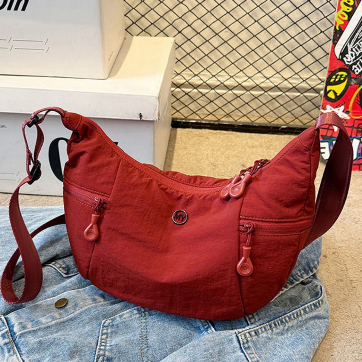Red nylon crossbody bag with adjustable strap and multiple zip pockets