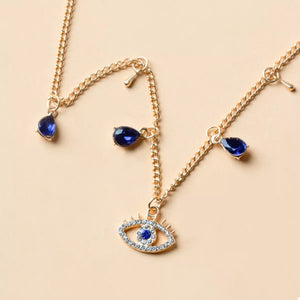 Gold evil eye charm necklace with blue teardrop gems