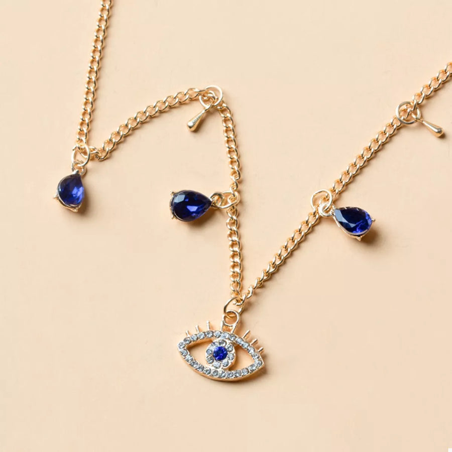 Gold evil eye charm necklace with blue teardrop gems