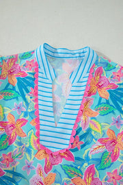 Tropical floral v-neck dress with blue striped trim and pink scalloped edge detail.