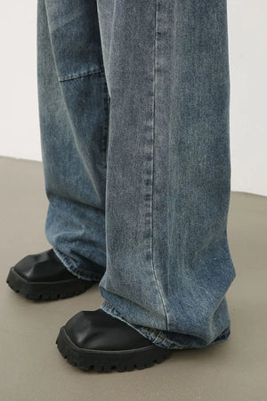 Distressed edge wide-leg denim jeans in medium wash, showing a relaxed fit and casual styling.
