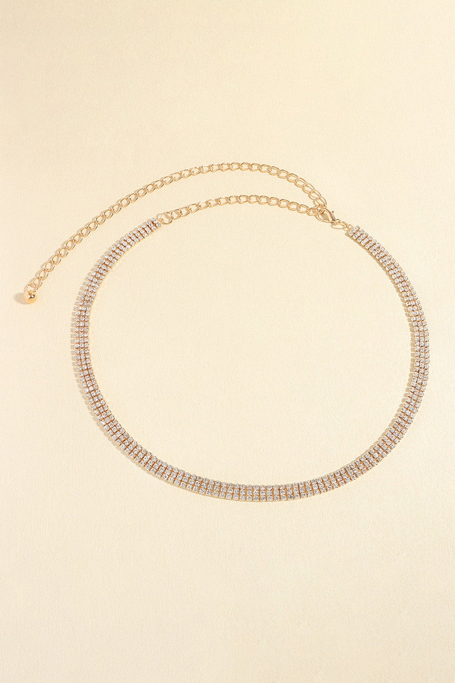 Gold triple-row crystal waist chain with adjustable link chain and clasp.
