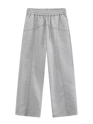 Gray cotton drawstring sweatpants with wide legs and seam details.