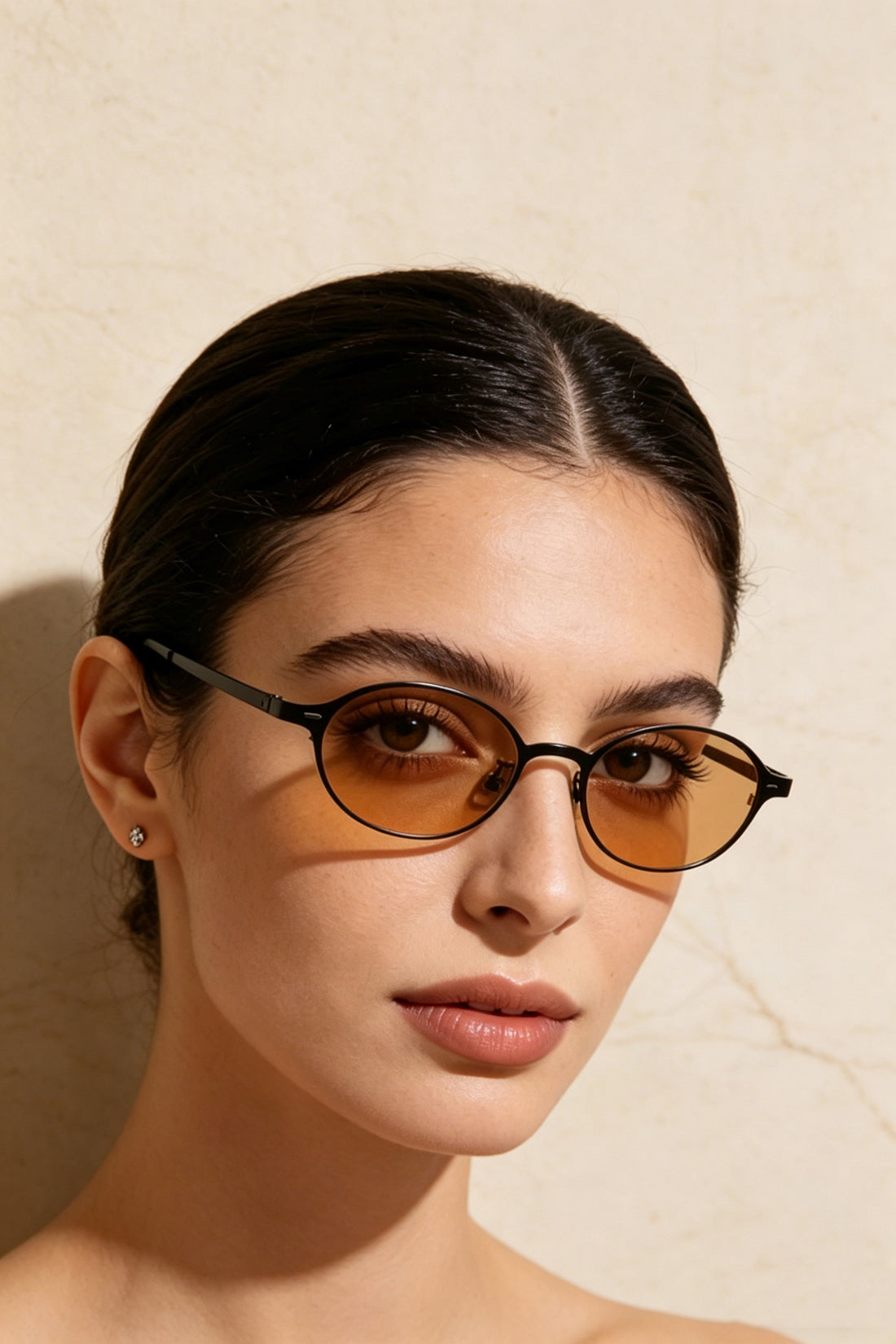 Black oval sunglasses with orange tinted lenses