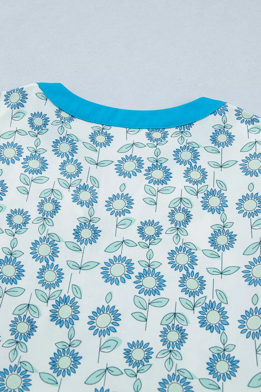 Floral dress in pastel blue with notched neckline and cap sleeves