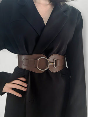 Brown elastic cincher belt with silver buckle detail worn over a black blazer.