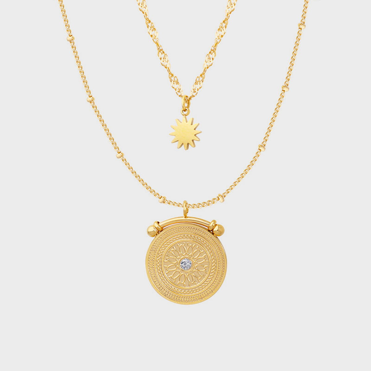 Gold celestial medallion layered necklace with sun charm and crystal accent
