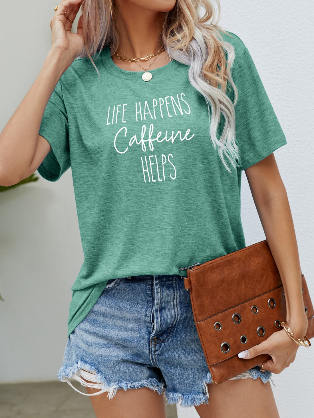 Green slub knit tee with white "Life Happens Caffeine Helps" graphic print.