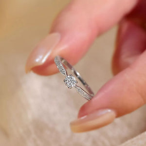 Elegant moissanite ring in sterling silver with a brilliant center stone and pave band.