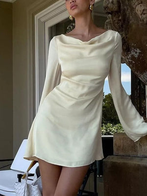 Cream satin mini dress with cowl neck and long sleeves.
