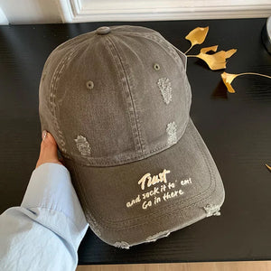 Distressed grey baseball cap with embroidered text and frayed details