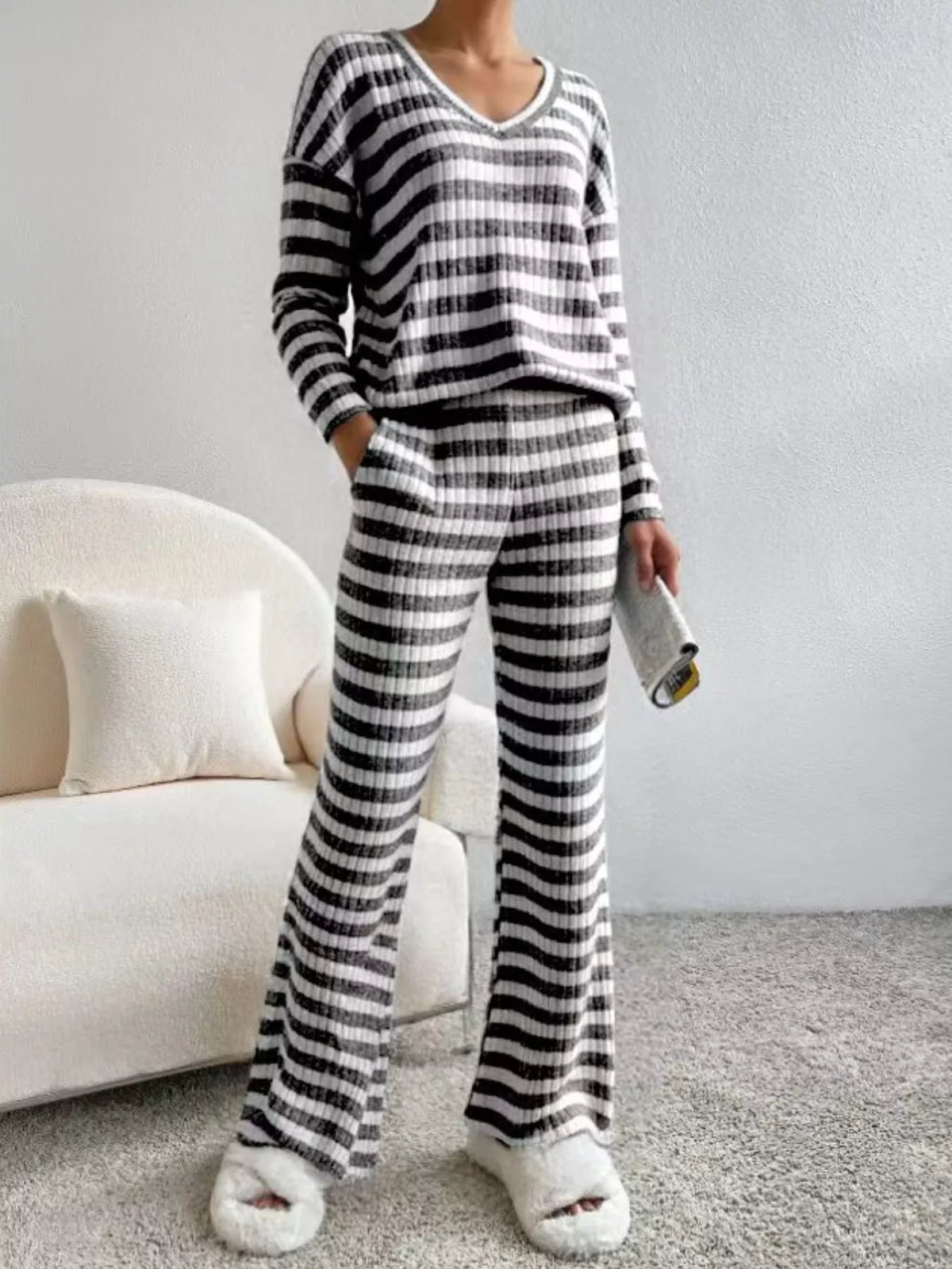 Black striped knit loungewear set with v-neck top and wide-leg pants.