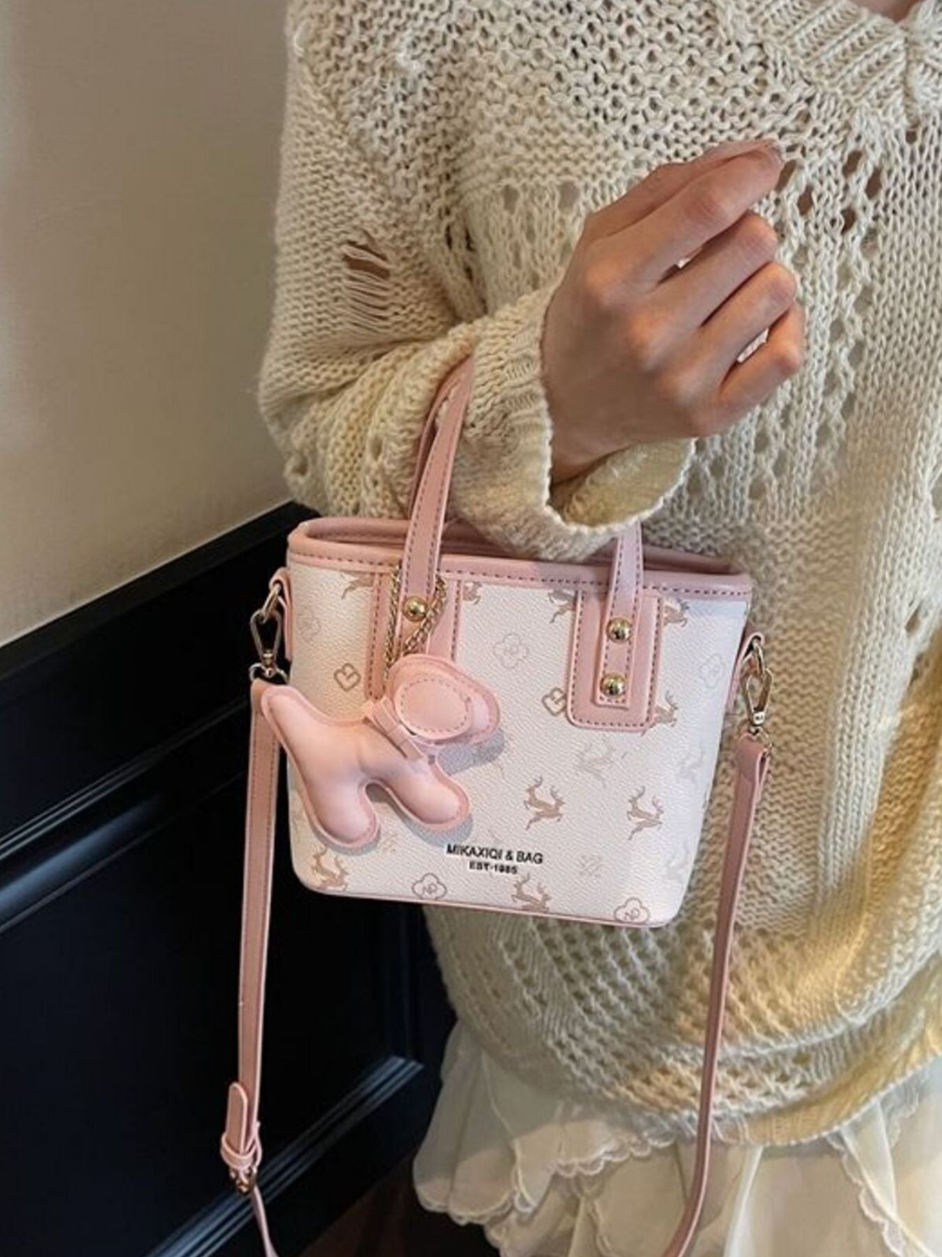 Charming mini crossbody bag in blush pink with a deer print and a cute pink charm.
