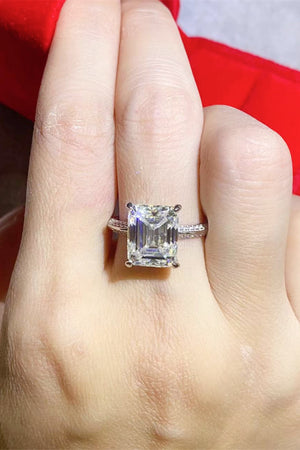 Platinum engagement ring with emerald cut solitaire diamond and pavé band.