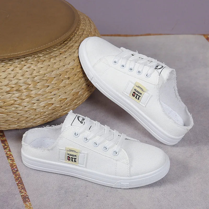 White denim mule sneakers with raw edges and lace-up front.