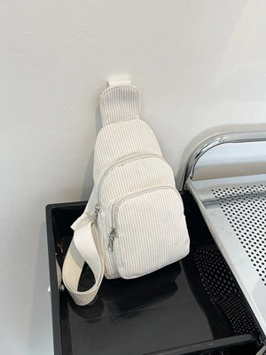 White corduroy sling bag with zip pockets and adjustable strap