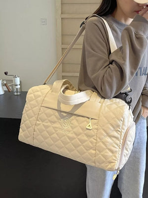 Diamond-stitched beige quilted duffel bag with adjustable strap and top handles.