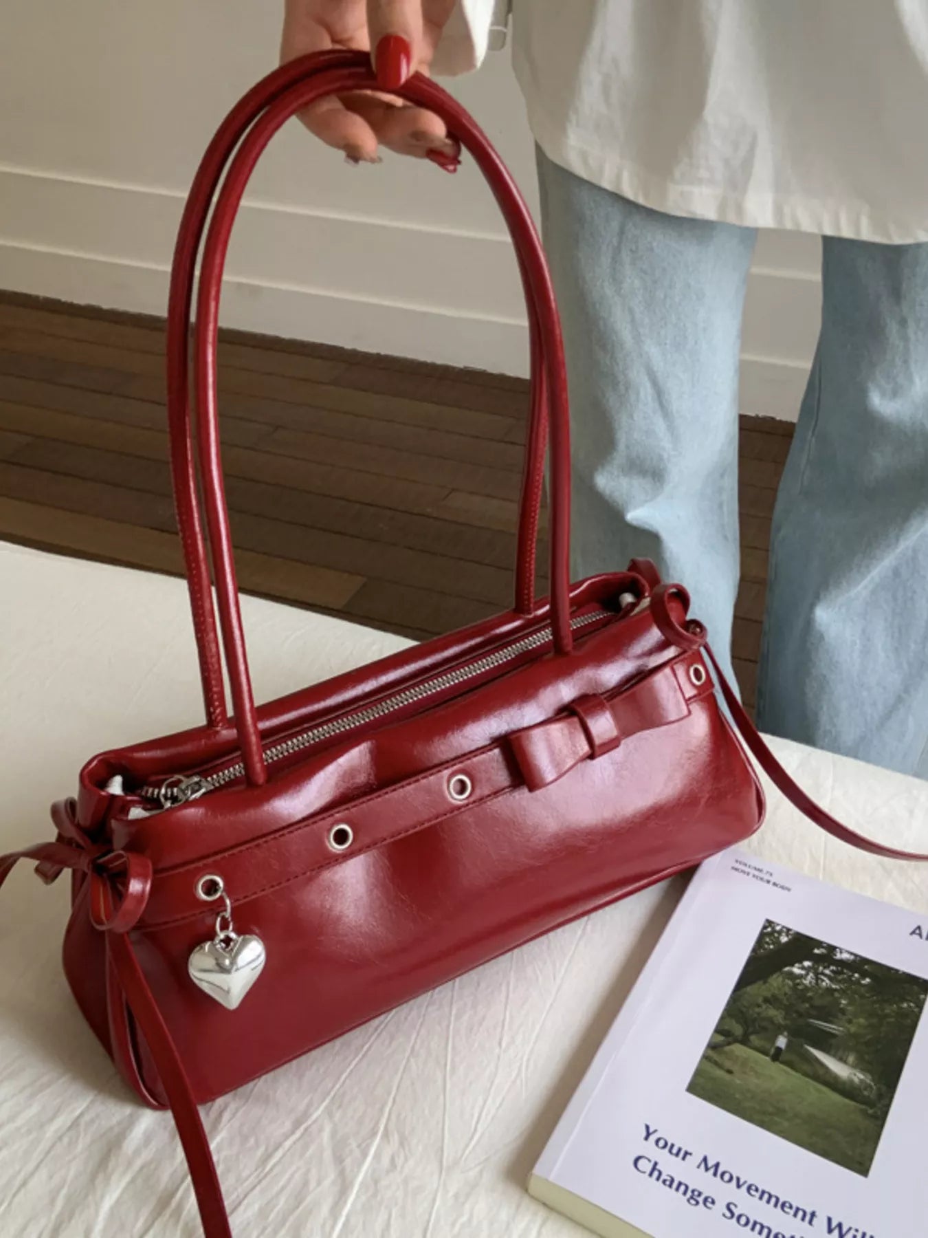 Red patent leather shoulder bag with bow detail and heart charm