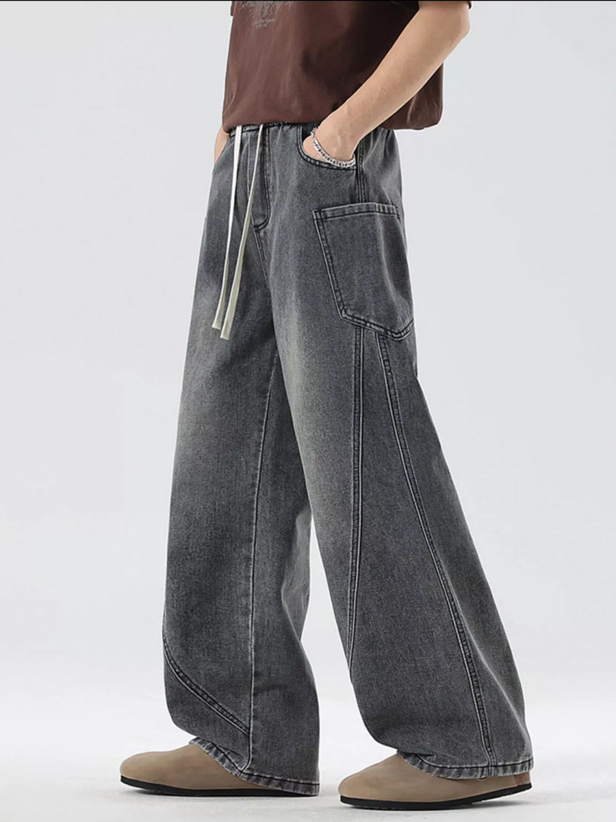 Oversized wide-leg jeans in smoky gray denim with a drawstring waist and vintage-inspired stitching.
