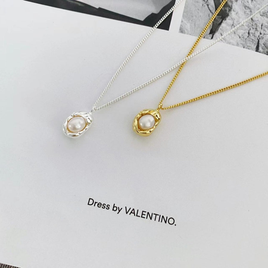Sterling pearl pendant necklace in silver and gold, featuring a delicate pearl set in an organic metal frame.