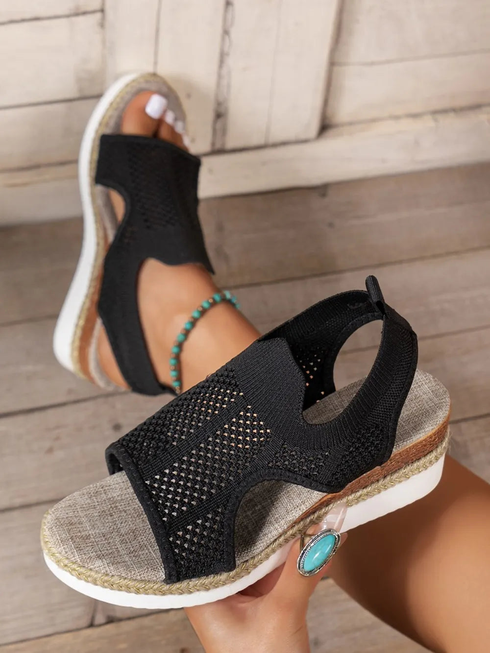 Black knit cutout espadrille wedge sandals with a woven sole detail.