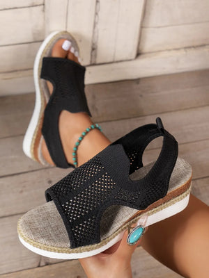 Black knit cutout espadrille wedge sandals with a woven sole detail.