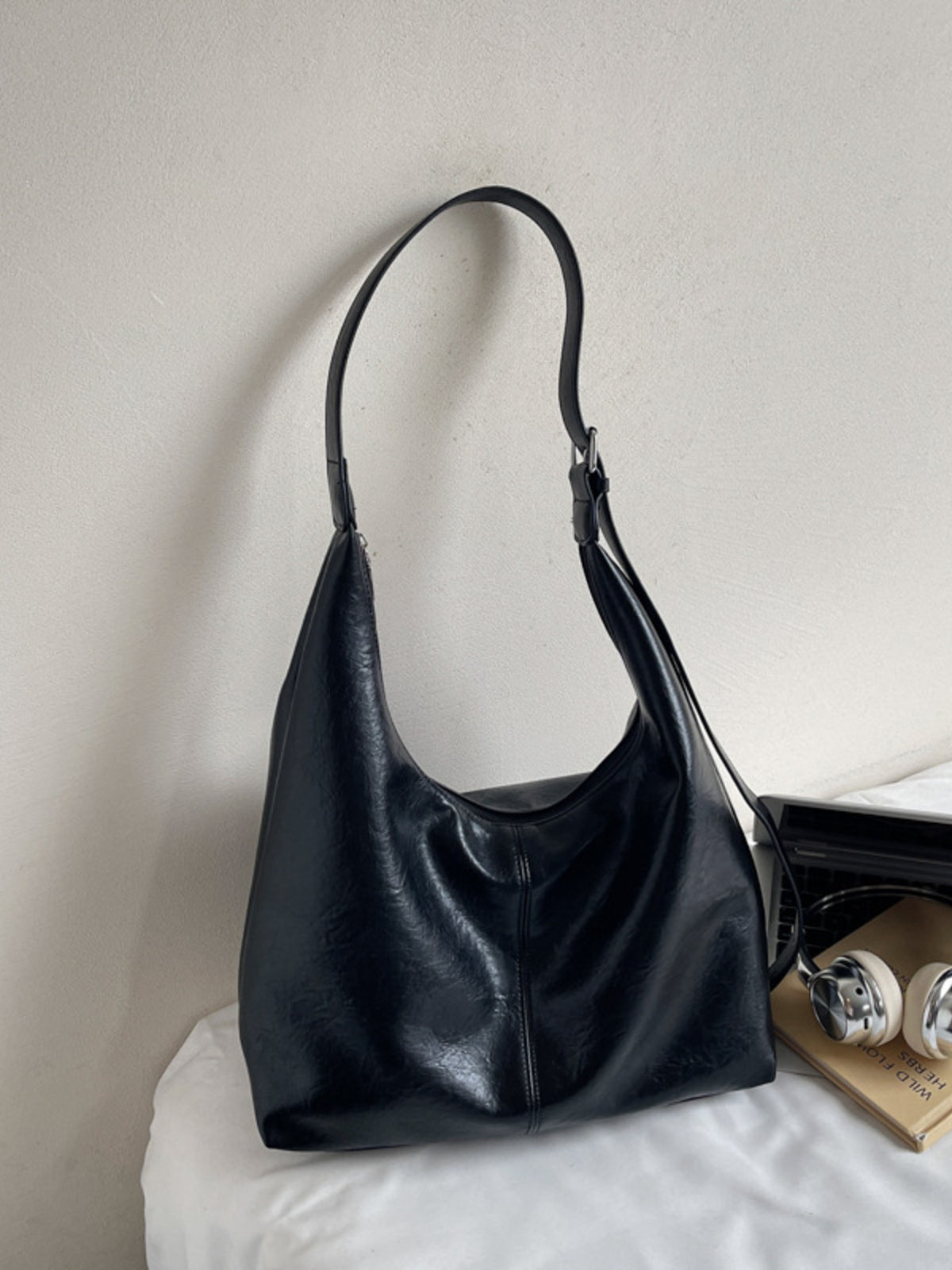 Black leather shoulder bag with adjustable strap and slouchy silhouette