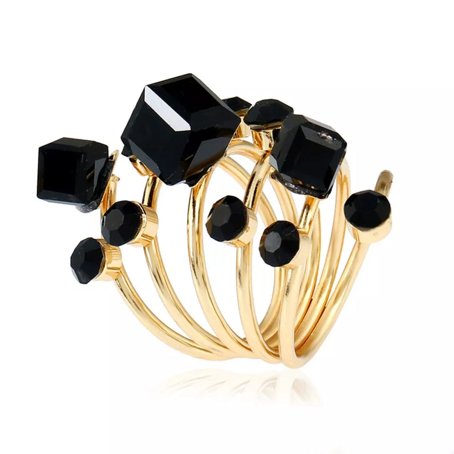 Gold-plated ring with black crystals and geometric shapes.