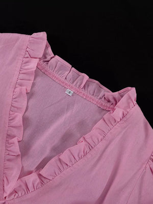 Pink ruffled v-neck blouse with a textured fabric and a size tag.