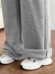 Gray wide-leg maternity joggers with cuffed hems shown with white sneakers.