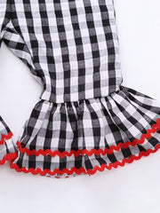 Black and white gingham baby jumpsuit with ruffled bell sleeves and red zigzag trim