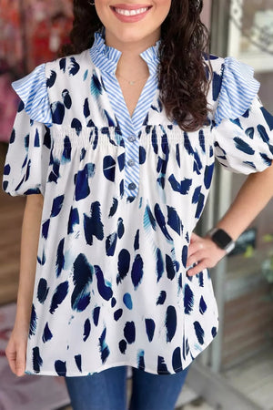 Vibrant abstract print polyester shirt with ruffled V-neck, button front, and short puff sleeves.