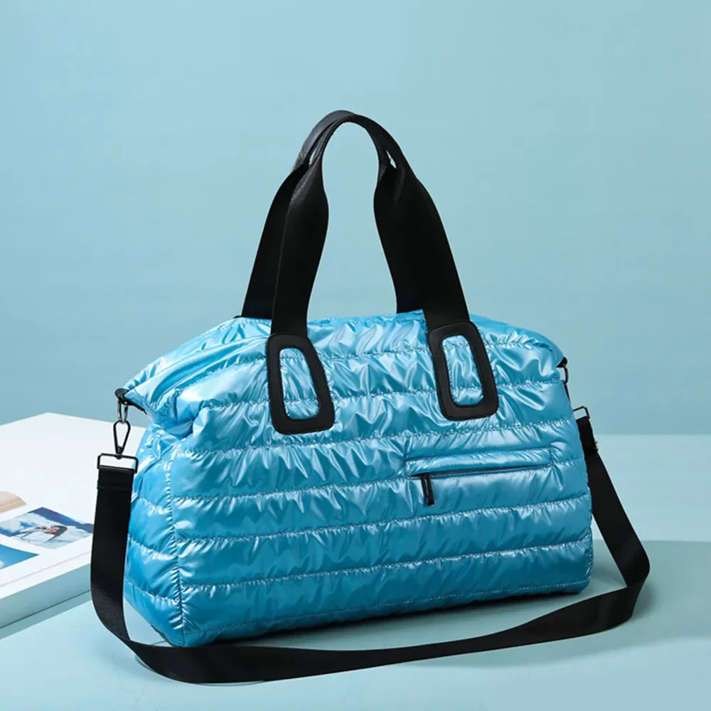 Glossy padded cerulean holdall bag with black straps and zipper pocket.