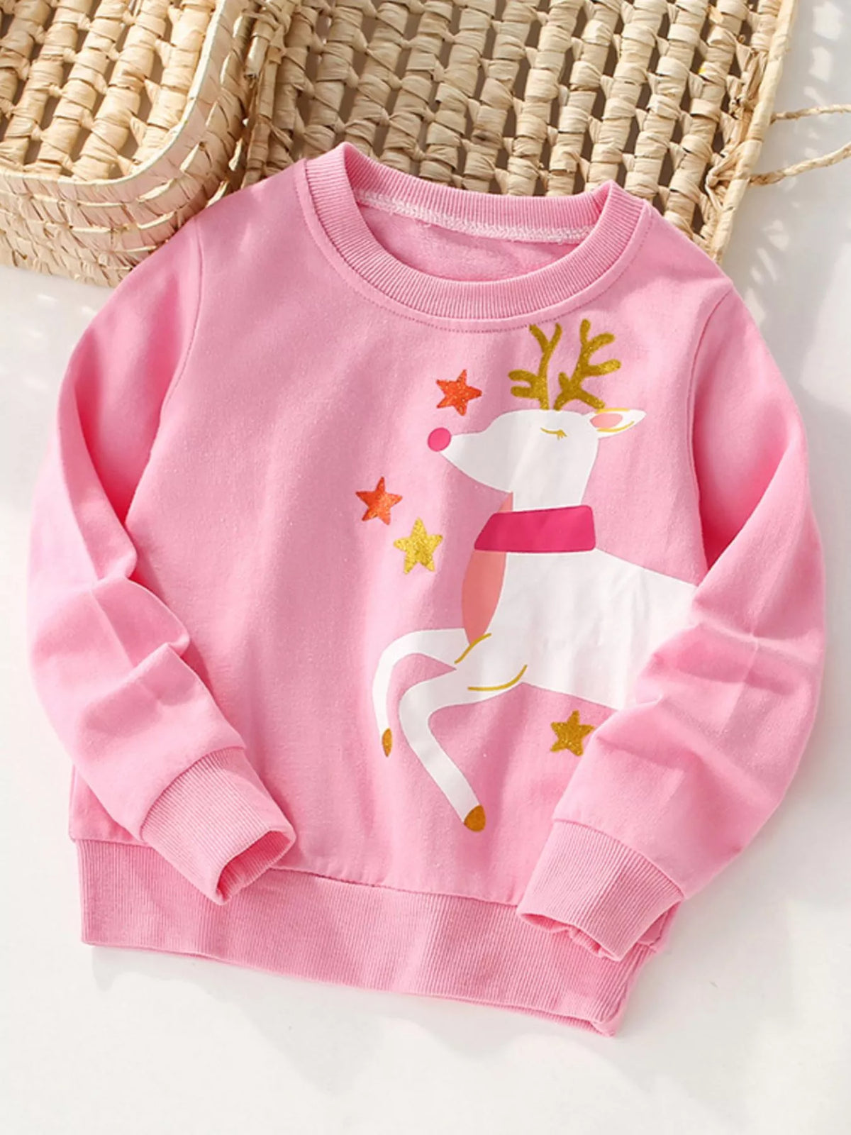 Pink crew neck sweatshirt with reindeer and stars graphic