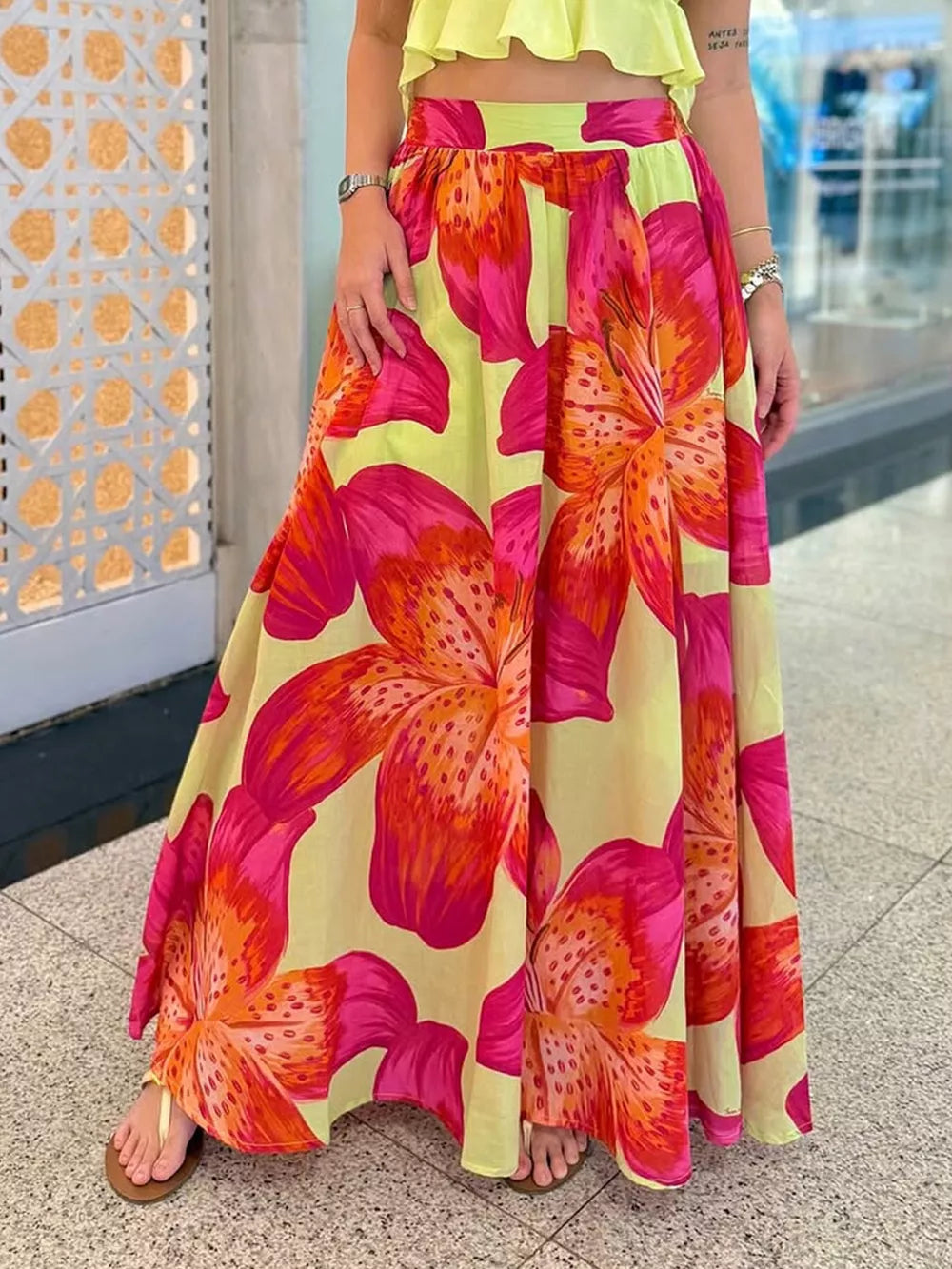 Vibrant floral maxi skirt in yellow with large pink and orange lily prints, ankle length, with pockets.