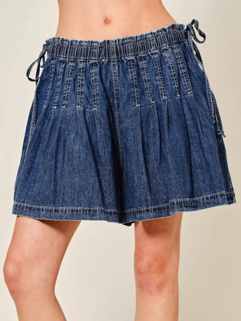 Dark blue denim-effect shorts with ruched waist and drawstring ties.