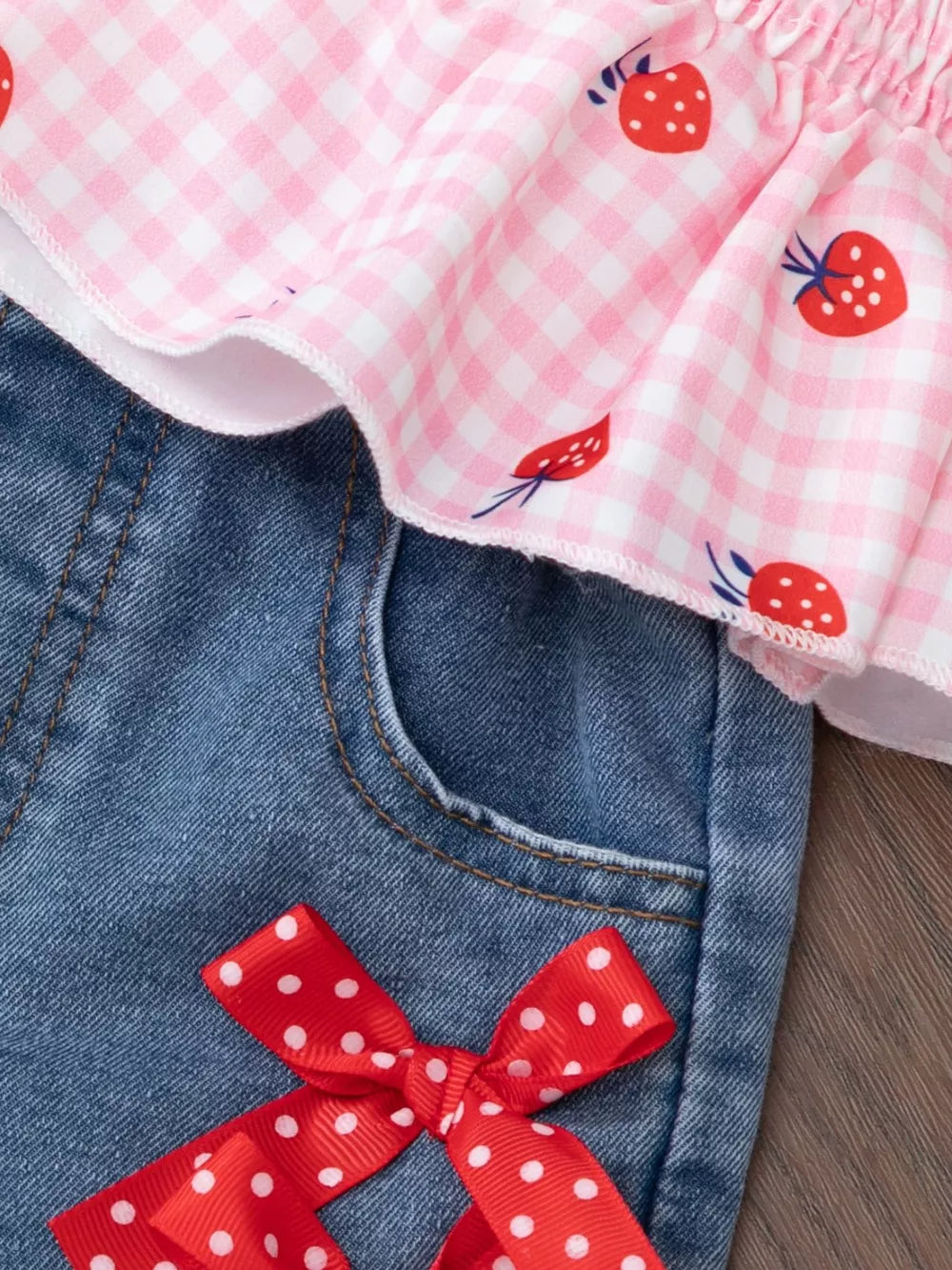 Baby girls' strawberry gingham smocked top and denim shorts with red polka dot bow.